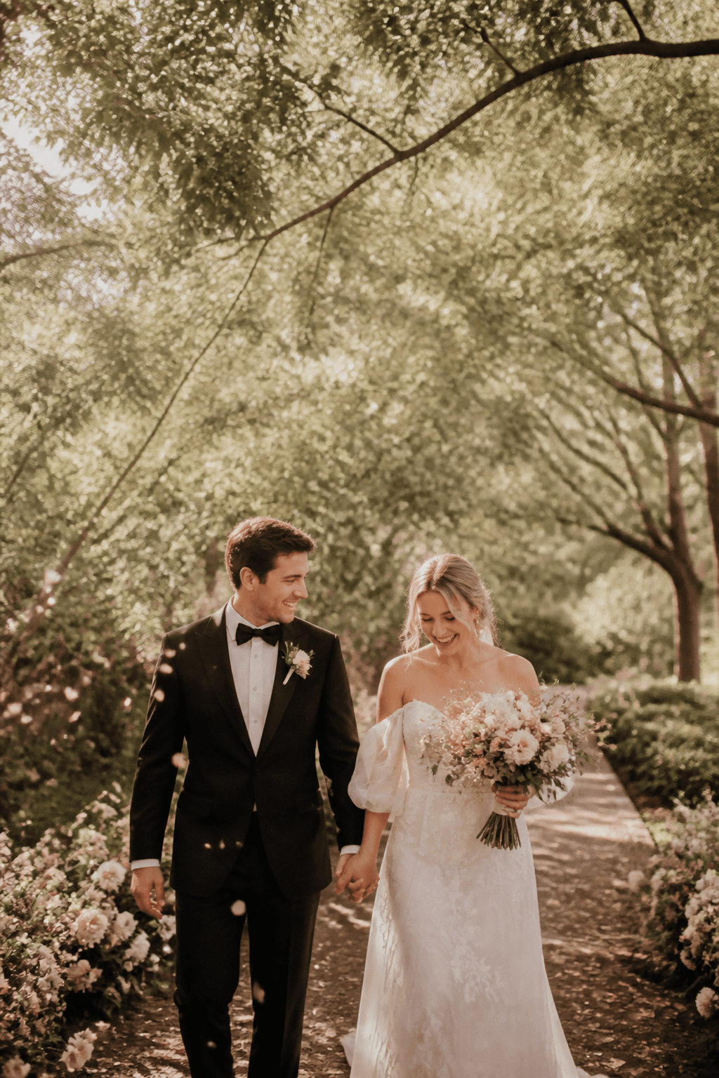 A couple walking through a sunlit garden
